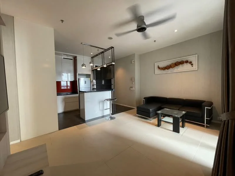 Living features: 3-seater black leather sofa, glass coffee table, ceiling fan, wall-mounted TV, decorative wall art, light-colored tiled flooring, recessed downlights, neutral painted walls, open layout to kitchen, large window with curtains; style: modern. Kitchen features: white cabinetry, black countertop, red backsplash, built-in oven, stainless-steel sink, chrome faucet, kitchen island with seating, recessed lighting; style: modern.