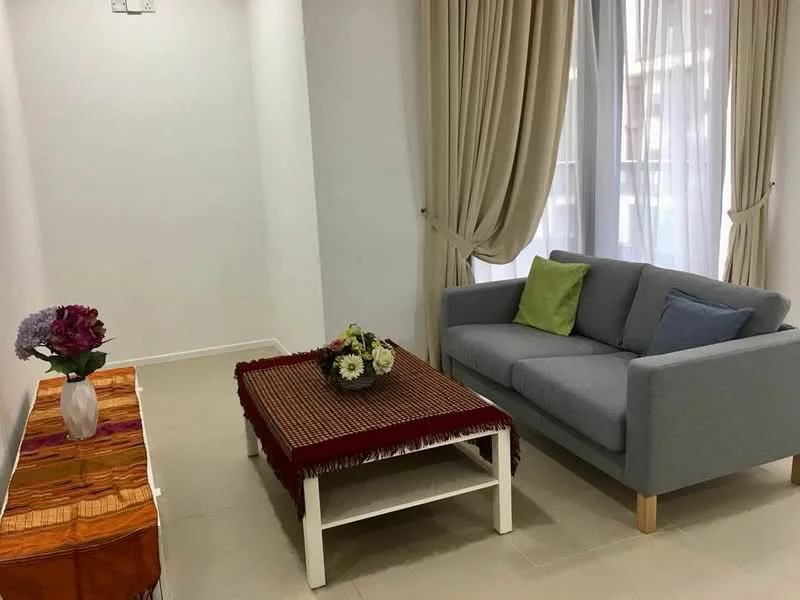 Living features: grey fabric sofa, wooden coffee table with decorative cloth, decorative flowers on coffee table, white walls, light-colored tiled flooring, floor-to-ceiling windows with sheer curtains, cream-colored drapes, decorative throw pillows in green and blue; style: modern.