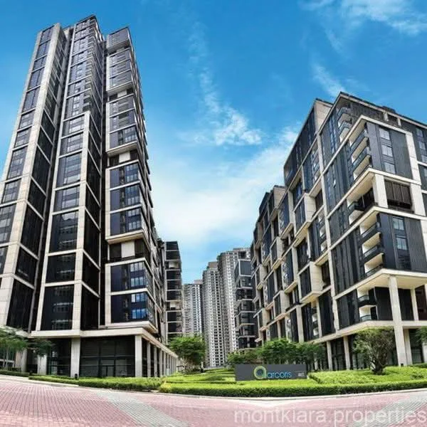 Exterior type: high-rise condominium; features: glass curtain wall, black facade, recessed balconies, landscaped garden, manicured lawn, paved driveway, multiple storeys, surrounded by greenery; style: modern.