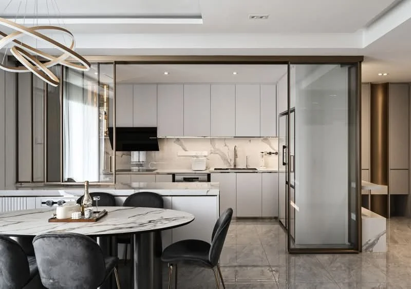 Kitchen features: marble countertop, white cabinetry, built-in oven, stainless-steel fridge, ceramic tile flooring, recessed downlights, glass sliding door, black wall-mounted TV, modern pendant lighting, open shelving, kitchen island, 4-burner gas hob, chrome pull-down faucet, white subway tile backsplash; style: modern. Dining features: round dining table, upholstered dining chairs, decorative centerpiece, wall-mounted decor; style: modern.