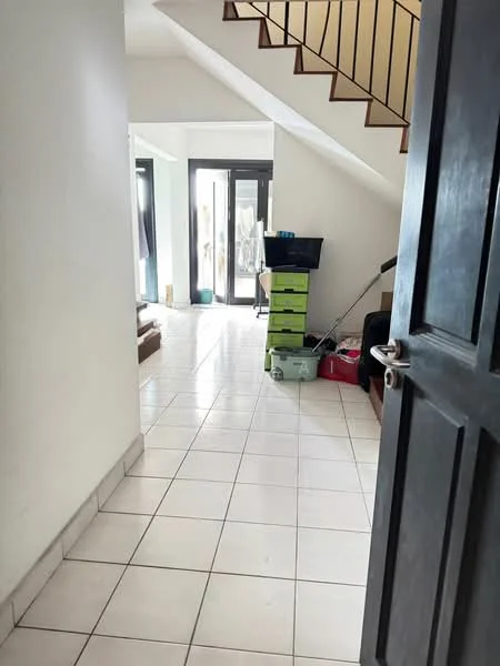 Room features: white painted walls, tile flooring, staircase with wooden handrail, floor-to-ceiling windows, sliding glass door, open layout, storage boxes in various colors, black sofa, television stand, natural light from windows; style: modern.