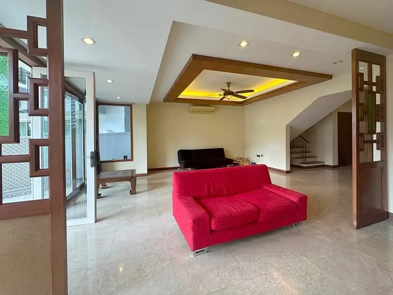 Living features: red fabric sofa, coffee table, marble flooring, tray ceiling with recessed lighting, 5-blade ceiling fan, wall-mounted TV, large windows, wooden door with glass panel, staircase leading to upper floor, air conditioning unit; style: modern.
