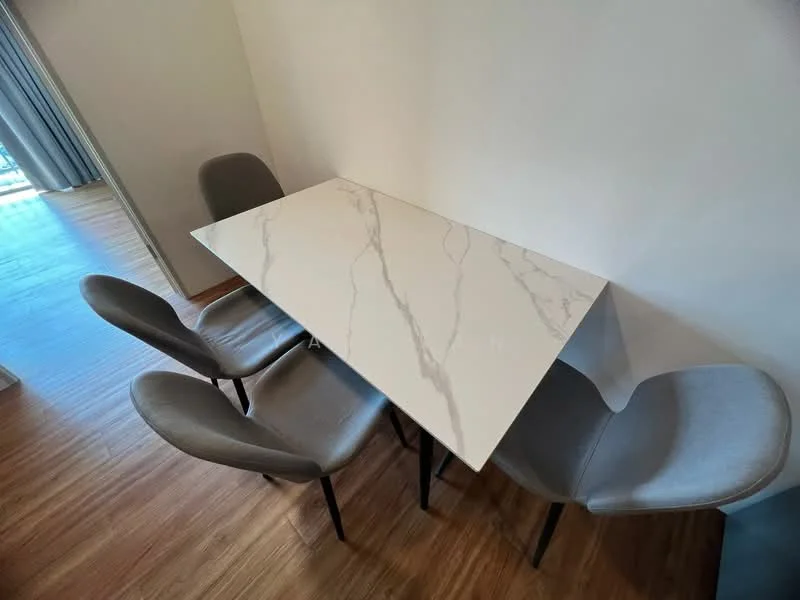 Dining features: marble dining table with veining, 4 upholstered dining chairs in grey, wooden flooring, natural light from window, minimalist decor; style: modern.