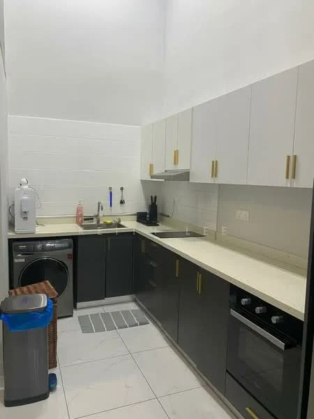 Kitchen features: grey cabinetry with gold handles, white upper cabinets, cream countertop, stainless-steel sink, chrome faucet, built-in oven, 4-burner gas hob, washing machine, tile flooring, white tiled backsplash, recessed lighting, kitchen waste bin, open shelving, kitchen towel rack; style: modern.