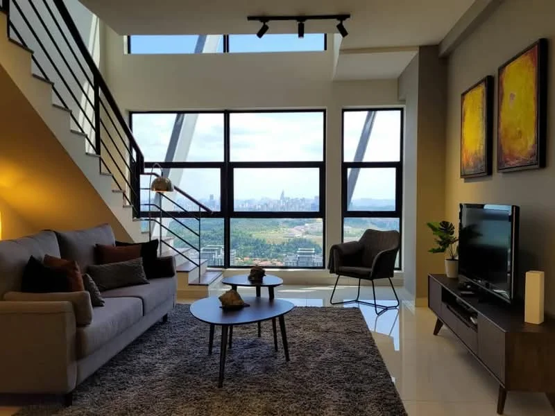 Living features: 3-seater fabric sofa in grey, coffee table, TV console, wall-mounted TV, area rug with geometric pattern, floor-to-ceiling windows, city skyline view, recessed downlights, decorative wall art, lampshade floor lamp, open staircase with metal railing, polished tile flooring, plant in ceramic pot; style: modern; view: city.