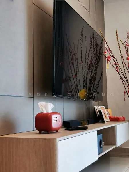 Living features: wall-mounted flat-screen TV, light grey wall paneling, wooden TV console with white drawer, decorative red vase with branches, tissue box, photo frames on console, black soundbar, minimalist decor; style: modern.