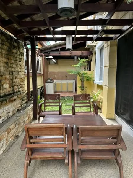 Room features: wooden dining table, wooden chairs, exposed wooden beams, stone wall, green grass, outdoor kitchen area, cooking range, sink, paved flooring, overhead lighting; style: modern; view: garden.