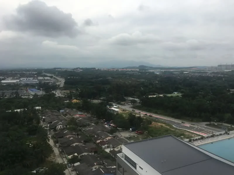 Exterior type: high-rise condominium; features: city skyline view, surrounded by greenery, adjacent to main road, view of residential area, cloudy sky, distant mountains; style: modern.