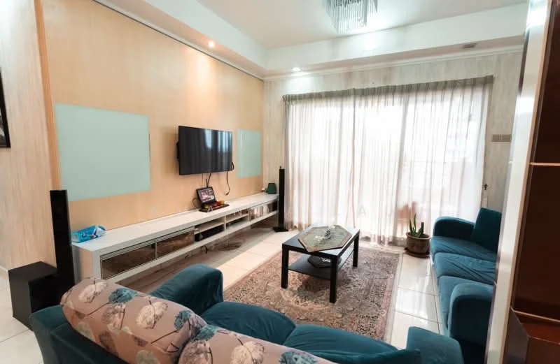 Living features: blue fabric sofa, 2-seater sofa, 3-seater sofa, glass coffee table, wall-mounted TV, white TV console, cream painted walls, recessed lighting, curtains, tile flooring, potted plant, decorative wall paneling; style: contemporary.