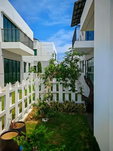 Exterior type: linked terrace house; features: white painted facade, glass windows, manicured lawn, fenced garden with white picket fence, balconies on upper floors, landscaped garden with shrubs, paved walkway, greenery surrounding the property; style: modern.