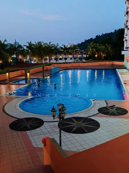 Exterior type: swimming pool deck; features: infinity pool, pool deck with loungers, tropical landscaping with palm trees, decorative stone paving, outdoor lighting, water feature, surrounding greenery, city skyline in background; style: modern.