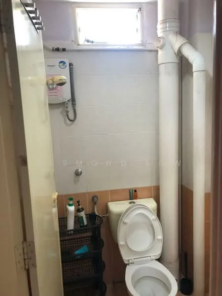 Bathroom features: white tiled walls, brown tiled flooring, one-piece toilet, sink with chrome faucet, shower head, shower hose, wall-mounted water heater, storage rack, toiletries on rack.