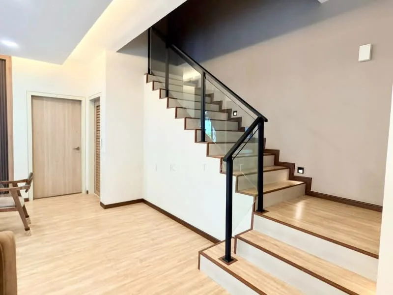 Room features: wooden staircase with glass railing, light wood flooring, cream painted walls, recessed lighting, doorway to adjacent room, wall-mounted light fixture, open space layout; style: modern.