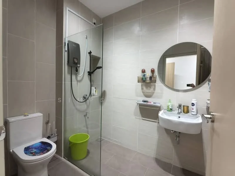 Bathroom features: glass shower enclosure, rain shower head, handheld shower, white ceramic sink, chrome basin mixer, one-piece toilet, grey tiled walls, grey tiled flooring, round mirror, green bucket, wall-mounted soap dispenser, toiletries on shelf; style: modern.