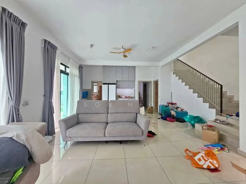 Living features: grey fabric sofa, white walls, cream tiled flooring, 5-blade ceiling fan, large windows with sheer curtains, open layout to kitchen, decorative wall with staircase, natural light from windows, various items on the floor; style: modern.