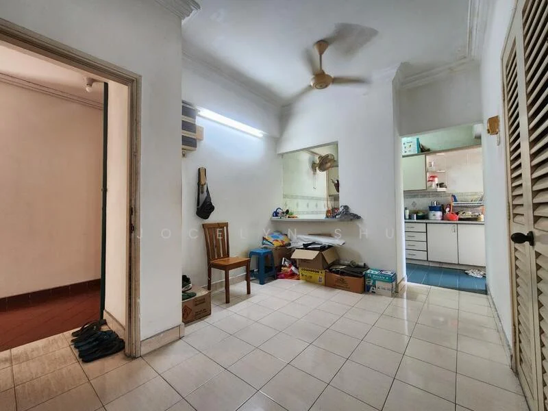 Room features: white painted walls, tile flooring, ceiling fan, built-in cabinetry, open layout, kitchen area visible, boxes and clutter, light fixture, doorway leading to another room.
