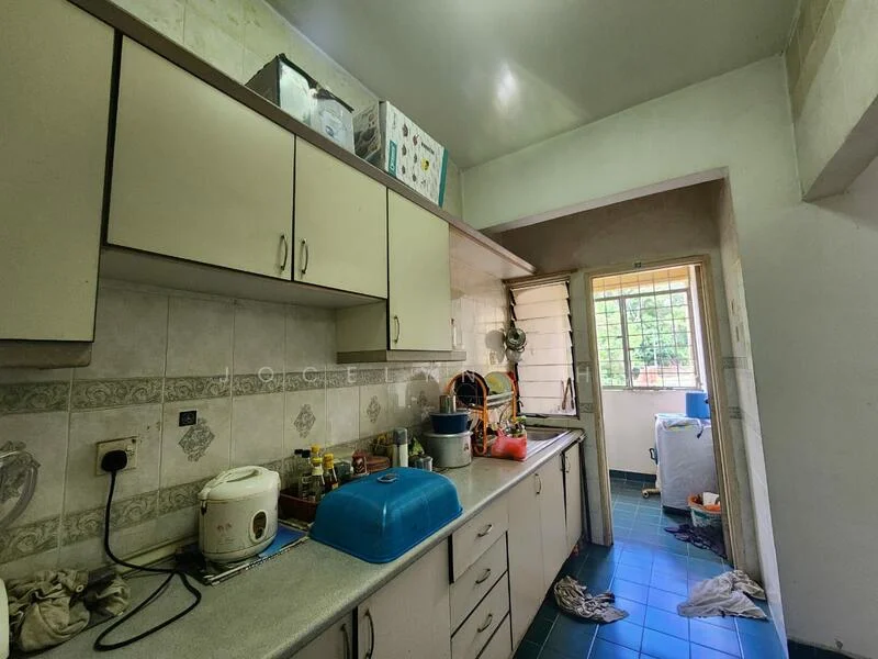 Kitchen features: light grey cabinetry, grey countertop, blue single-bowl plastic sink, chrome faucet, white tiled backsplash, green ceramic tile flooring, window with grid pattern, kitchen appliances visible, cluttered countertop with various items.