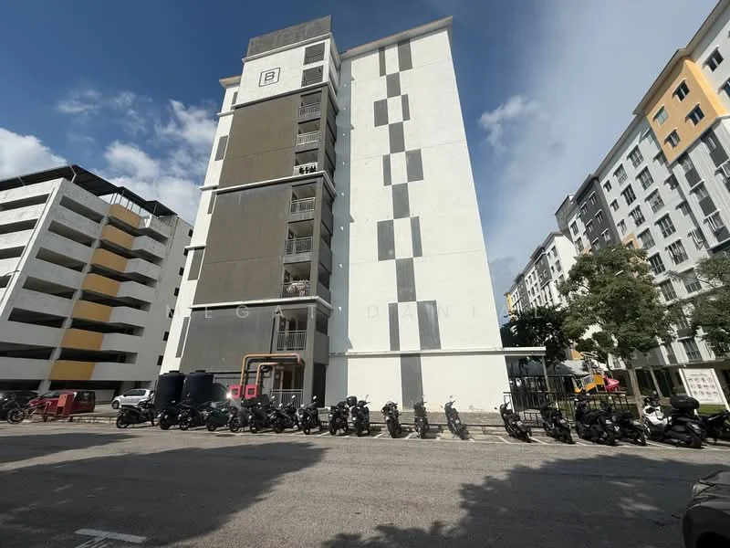 Exterior type: mid-rise condominium; features: grey painted facade, white painted facade, balconies visible on upper floors, multiple storeys, parking deck visible on left, row of motorcycles parked in front, surrounded by trees, urban setting; style: modern.