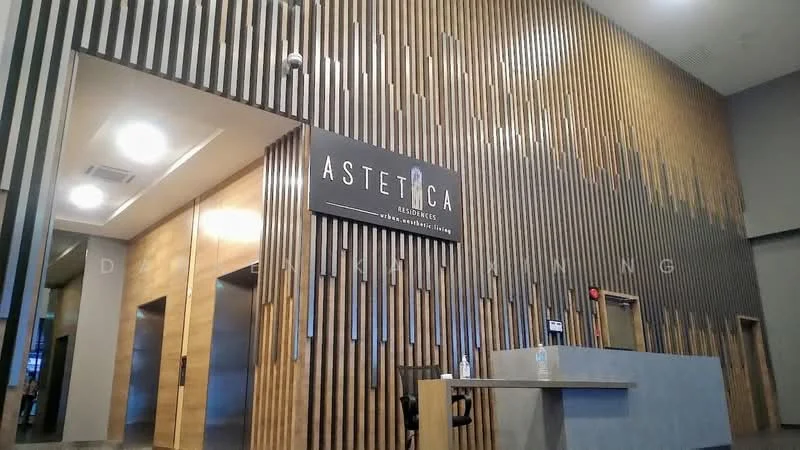 Room features: wood paneling on walls, reception desk, signage with logo, recessed lighting, high ceiling, neutral color scheme, elevators visible, modern design; style: modern.