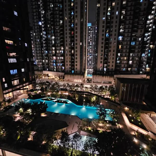 Exterior type: high-rise condominium; features: illuminated swimming pool, landscaped garden with greenery, multiple high-rise towers, balconies on residential units, night lighting, water features, pool deck with loungers, surrounding urban skyline; style: modern.
