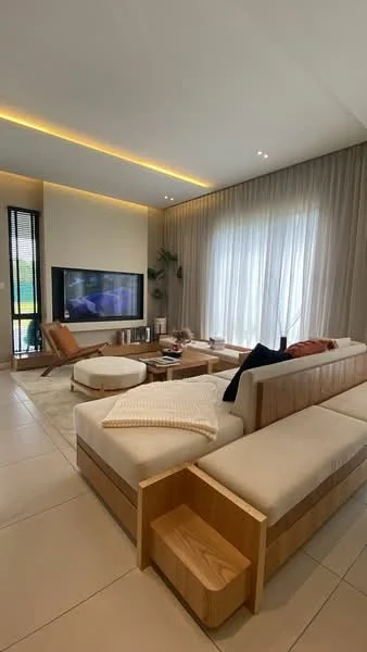 Living features: L-shape sectional sofa in beige, wooden coffee table, wall-mounted TV, floor-to-ceiling windows, sheer curtains, recessed LED downlights, decorative plants, light-colored tile flooring, area rug, wooden side table; style: modern; view: garden.
