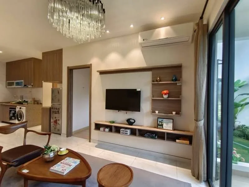 Living features: 3-seater fabric sofa in brown, wooden coffee table, TV console with wall-mounted TV, decorative shelf with plants and decor items, recessed downlights, wall-mounted split AC, large sliding glass door, floor-to-ceiling windows, light-colored tile flooring, area rug with neutral color, decorative wall art, curtains, open layout to kitchen, greenery view from window; style: modern; view: garden.