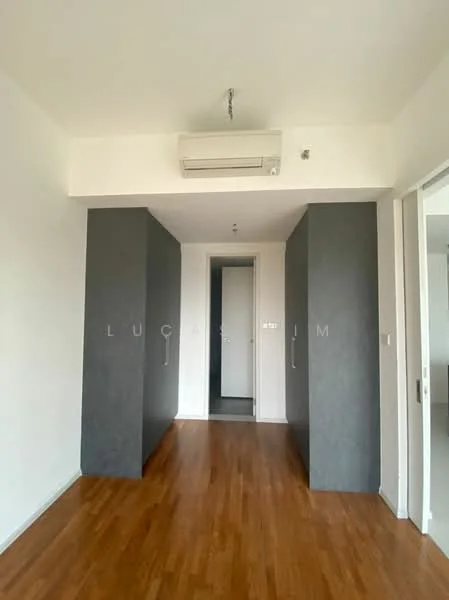 Room features: wooden flooring, grey accent wall, white painted walls, 1 wall-mounted split AC, doorway leading to another room, recessed ceiling lights, built-in wardrobes, neutral color scheme; style: modern.
