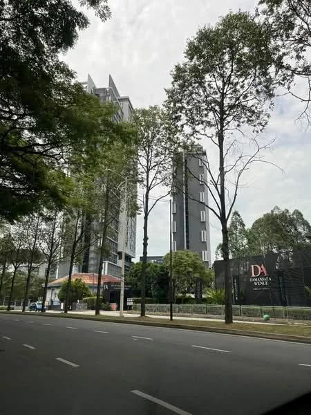 Exterior type: high-rise condominium; features: glass curtain wall, exposed concrete facade, recessed balconies, vertical fins, manicured lawn, mature trees, surrounded by greenery, double-volume main lobby, feature lighting at night; style: modern.