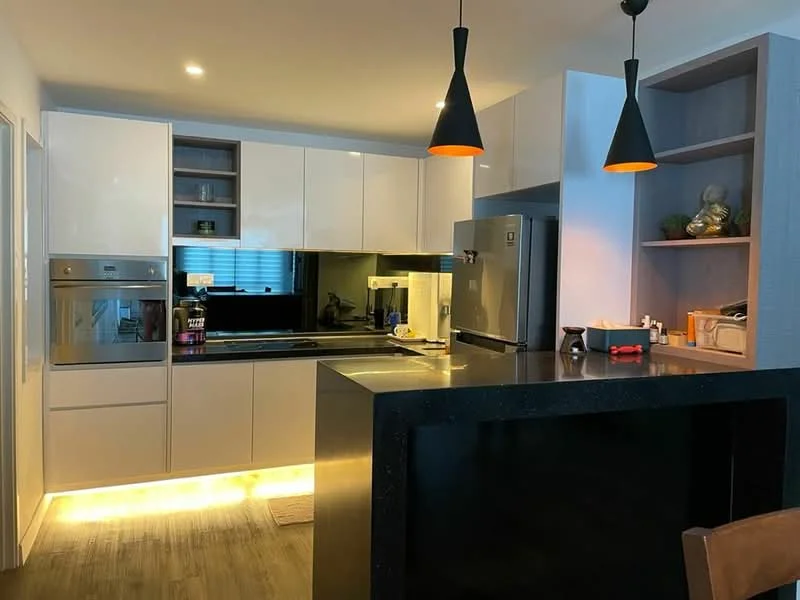 Kitchen features: white high-gloss cabinetry, black countertop, built-in oven, stainless-steel fridge, black glass cooktop, black backsplash, under-cabinet lighting, pendant lighting, open shelving, wooden flooring, sink, kitchen island with seating; style: modern.