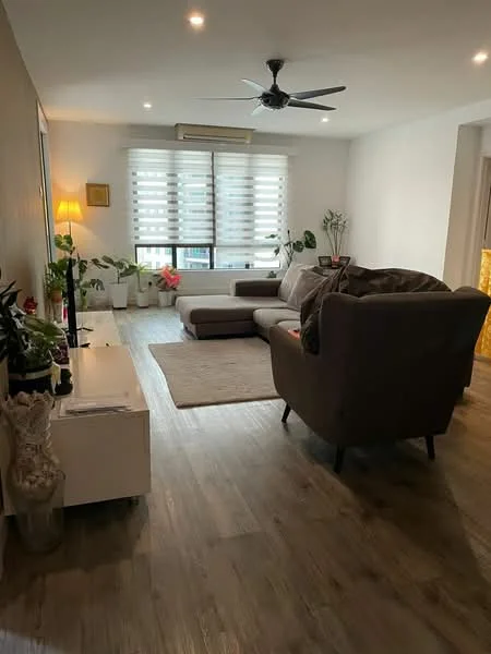 Living features: 3-seater fabric sofa in grey, L-shape sectional sofa, coffee table, area rug, floor-to-ceiling windows with blinds, wooden flooring, ceiling fan, wall-mounted air conditioning unit, decorative plants, side table with lamp, wall-mounted artwork; style: modern.