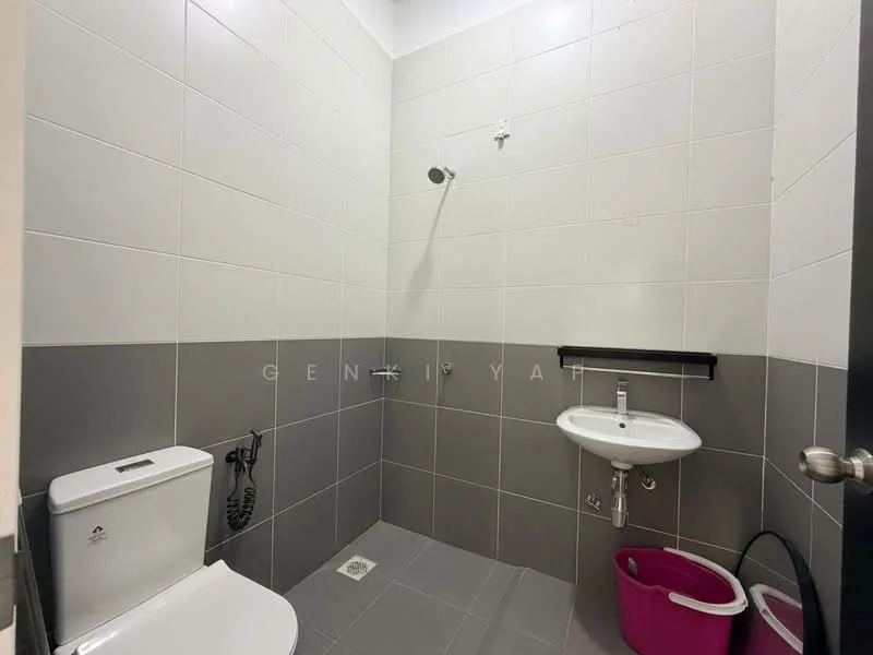 Bathroom features: white ceramic toilet, chrome bidet spray, single-sink vanity with wall-mounted faucet, mirror above sink, shower area with wall-mounted shower head, grey and white tiled walls, grey floor tiles, pink waste bin, black shelf above sink; style: modern.