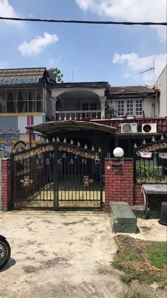 Exterior type: linked terrace house; features: brick facade, gated entrance with wrought iron gate, two-storey structure, visible air conditioning units, front yard with concrete paving, decorative wall with stone cladding, overhanging roof, windows with metal grilles, laundry area with clothes hanging, mature trees in vicinity; style: traditional.