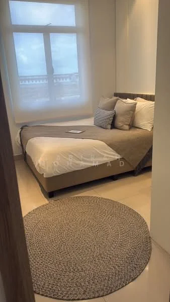 Bedroom features: king-size bed, upholstered headboard, bedding in neutral tones, decorative pillows, round area rug, floor-to-ceiling window, sheer curtains, light-colored walls, recessed lighting, nightstand with no visible items; style: modern; view: city.