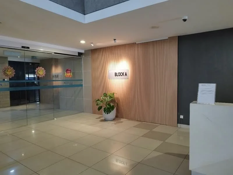 Room features: glass entrance door, wood paneling on wall, grey accent wall, tile flooring, reception desk, potted plant, signage with 'BLOCK A', decorative wall art; style: modern.