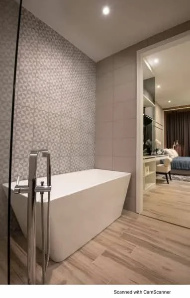 Bathroom features: freestanding bathtub, chrome floor-mounted faucet, geometric patterned wall tiles, neutral painted walls, wood-look tile flooring, recessed downlights, open space leading to bedroom, modern design; style: modern.
