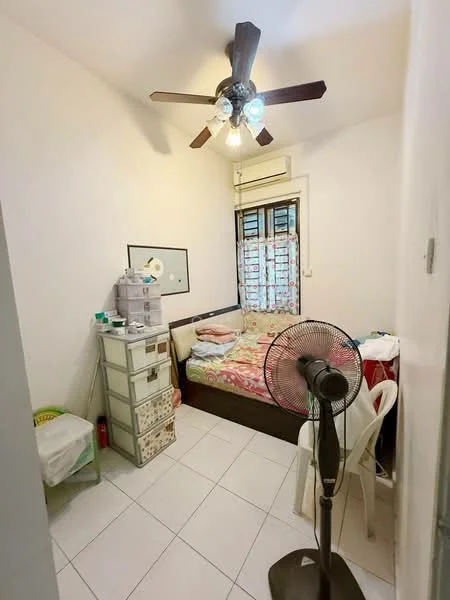 Bedroom features: queen-size bed with patterned bedding, white painted walls, white tiled flooring, 5-blade ceiling fan with light, window with sheer curtains, built-in wardrobe, plastic chair, standing fan, small bedside table, air conditioning unit.