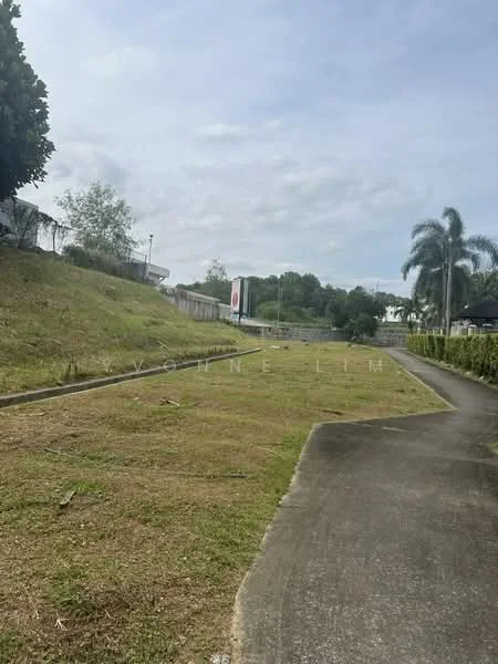 Exterior type: landscape garden; features: manicured lawn, paved walkway, surrounded by greenery, trees along the pathway, open space, fenced area, signage visible in the background; style: modern.