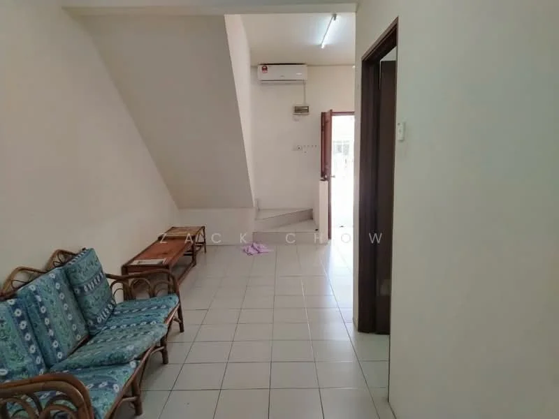 Room features: white painted walls, tiled flooring, 1 wall-mounted split AC, wooden door, staircase, 3-seater rattan sofa with blue cushions, wooden coffee table, natural light from door, ceiling light fixture; style: modern.
