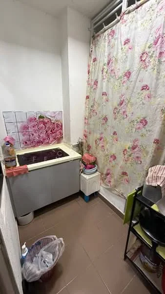 Kitchen features: single-bowl sink, countertop with floral design, grey cabinetry, wall-mounted tiles with floral pattern, floor tiles in brown, curtain with floral pattern, small trash bin, kitchen cart, stove with two burners.
