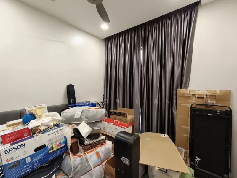 Room features: grey curtains, white painted walls, ceiling fan, cardboard boxes, various bags and items, sofa, cluttered space.