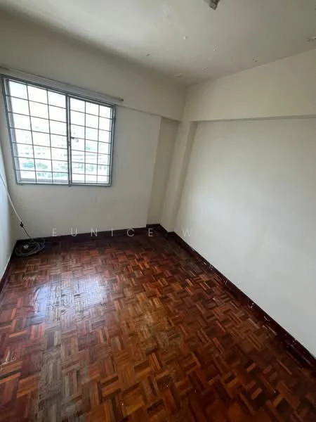 Room features: wooden flooring, white painted walls, large window with metal frame, natural light from window, corner room, no visible furniture, clean and empty space.