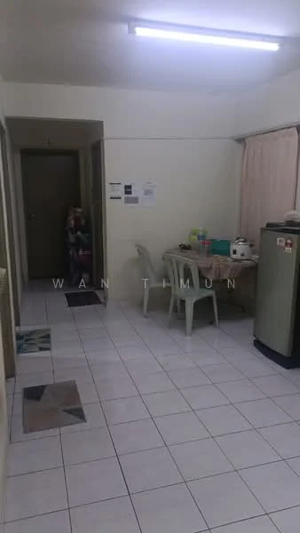 Room features: white painted walls, white tiled flooring, fluorescent ceiling lights, dining table with plastic chairs, refrigerator, kitchen appliances on countertop, doorway leading to hallway, decorative floor tiles, curtains on window, wall-mounted notices or papers; style: basic.
