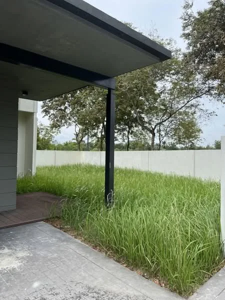 Exterior features: green grass lawn, concrete pathway, wooden deck, single-storey building, surrounding trees, fenced perimeter; style: modern.