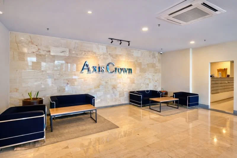 Lobby features: marble flooring, stone accent wall, blue fabric sofas, wooden coffee tables, recessed lighting, ceiling-mounted air conditioning unit, potted plant, reception desk visible in background; style: modern.