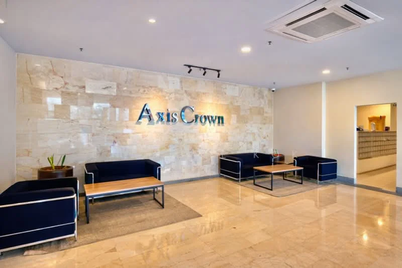 Lobby features: marble flooring, stone accent wall, blue fabric sofas, wooden coffee tables, recessed lighting, ceiling-mounted air conditioning unit, decorative plants, wall-mounted signage; style: modern.