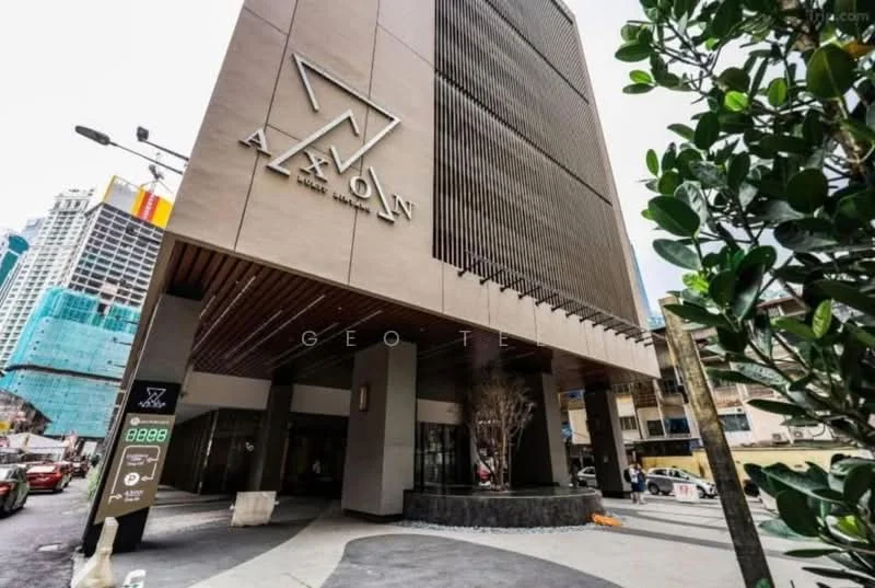 Exterior type: high-rise condominium; features: glass curtain wall, cream painted facade, recessed balconies, feature lighting at night, double-volume main lobby, landscaped entrance with planters; style: modern.