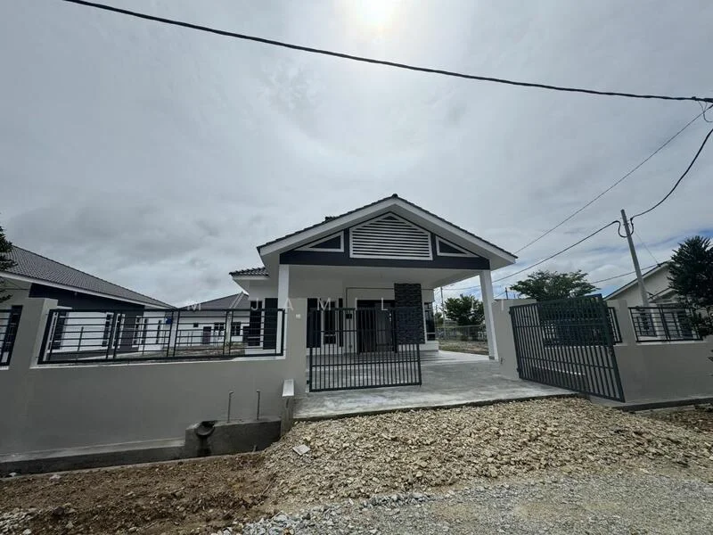 Exterior type: detached bungalow; features: white painted facade, grey stone cladding, pitched tile roof, manicured lawn, fenced perimeter, double-volume main entrance, concrete driveway, landscaped garden area, gated entry, surrounded by mature greenery; style: modern.