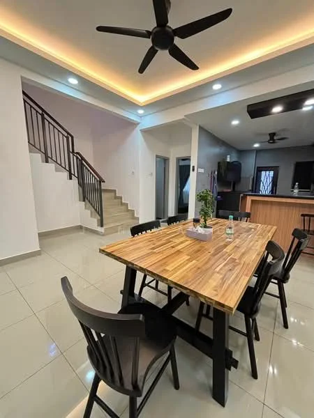 Dining features: wooden dining table with black legs, black dining chairs, recessed LED downlights, tray ceiling with ambient lighting, glossy tile flooring, open layout to kitchen, staircase in background, decorative plant on table; style: modern. Room features: white painted walls, ceiling fan, kitchen area visible in background.