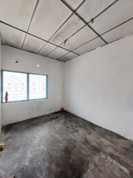 Room features: white painted walls, concrete flooring, two small windows with decorative grilles, exposed ceiling with grid, no visible fixtures or furniture.