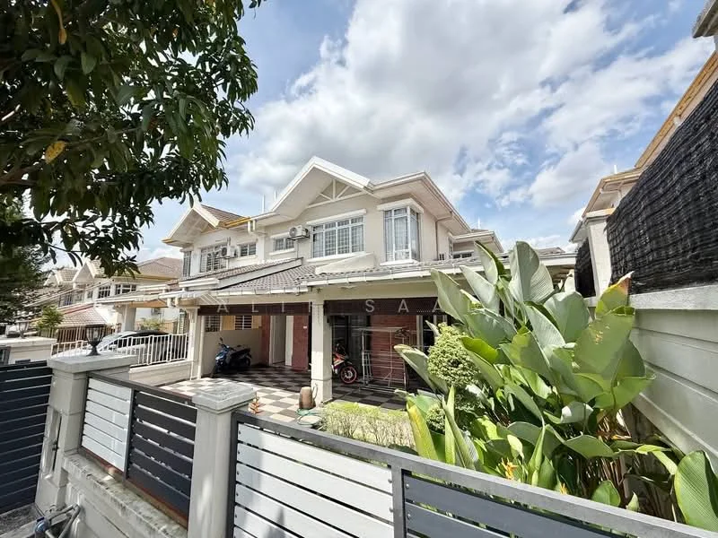 Exterior type: semi-detached house; features: white painted facade, pitched tile roof, manicured lawn, mature trees, tropical landscaping, driveway with interlocking pavers, front porch, balcony on upper floor, visible motorcycle parked, surrounded by greenery; style: modern.